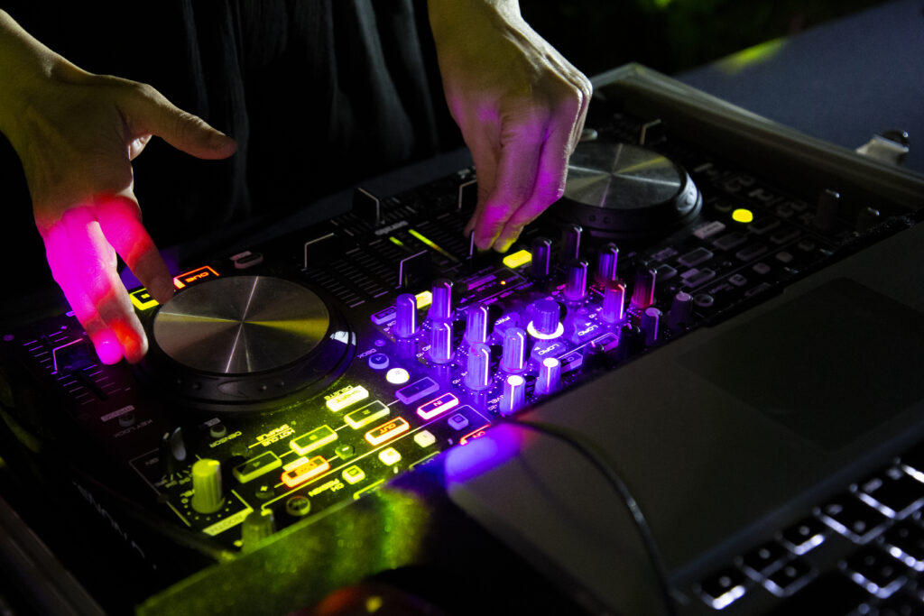 DJ working with his hands with disco lighting