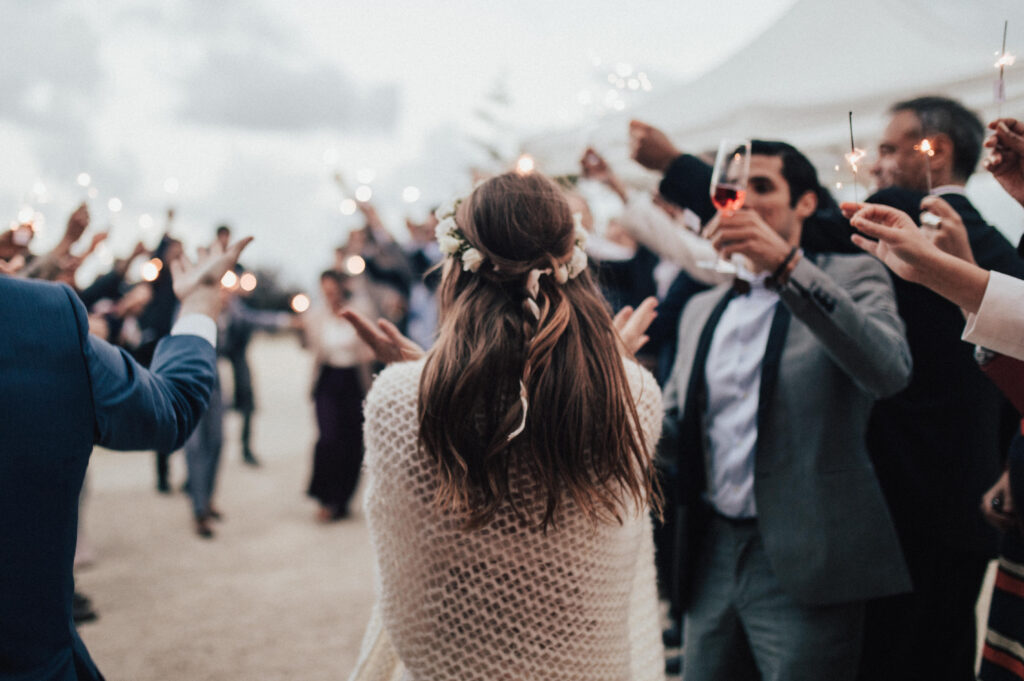 Novios siendo recibidos con bengalas por los invitados